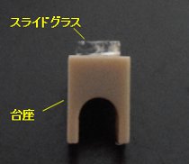 市販スライドグラスを2mm×5mmにカットして、平板試料測定用の台座に接着し、pH= 4、6、10の条件でゼータ電位を測定しました(写真)。 トレーサー粒子は、市販の二酸化けい素を使用し、0.1 mol/l HClと0.1 mol/l NaOHを添加してpHを調整しました。